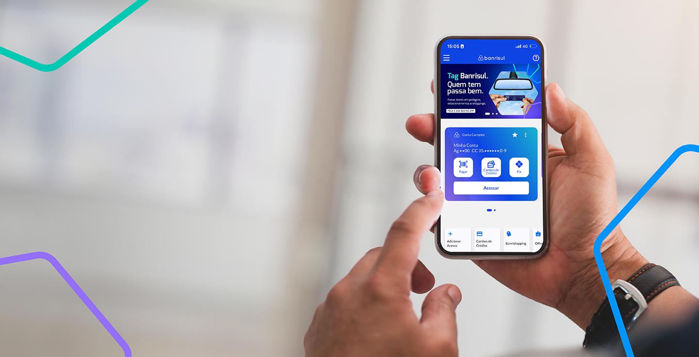 Foto de mo segurando celular com tela do app Banrisul.
