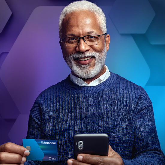 Homem sorrindo, segurando o cartão banrisul e o celular